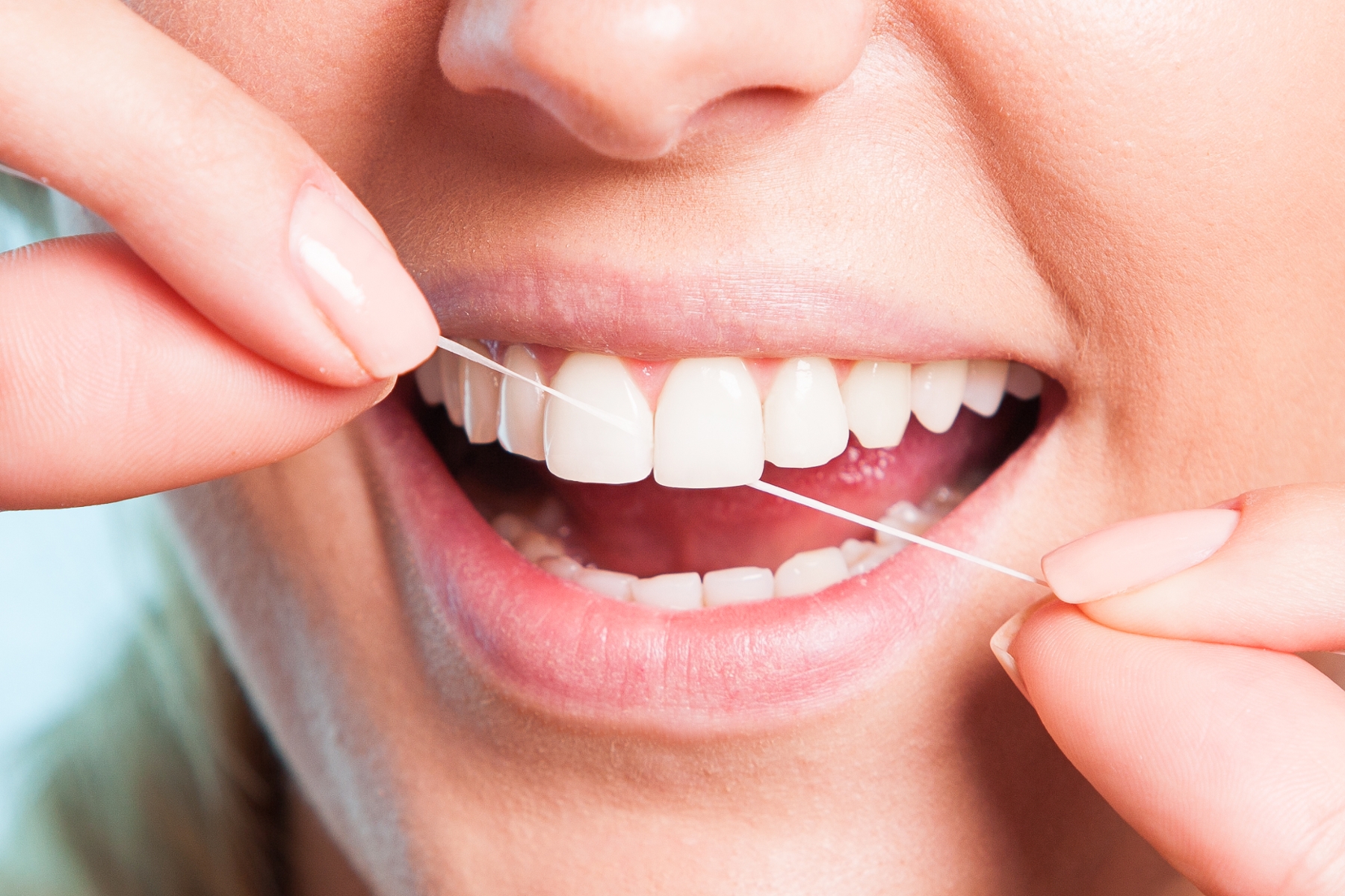 dental patient using dental floss getting ready for dental clean