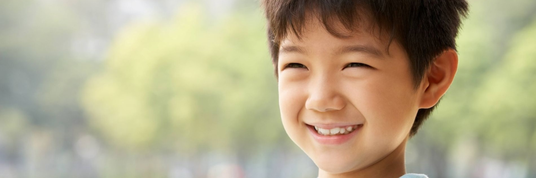 Young boy smiling outdoors at Leichhardt park