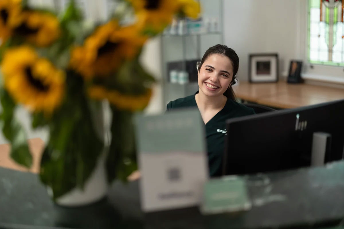 Radiance Dentistry | Smiling team member with flowers
